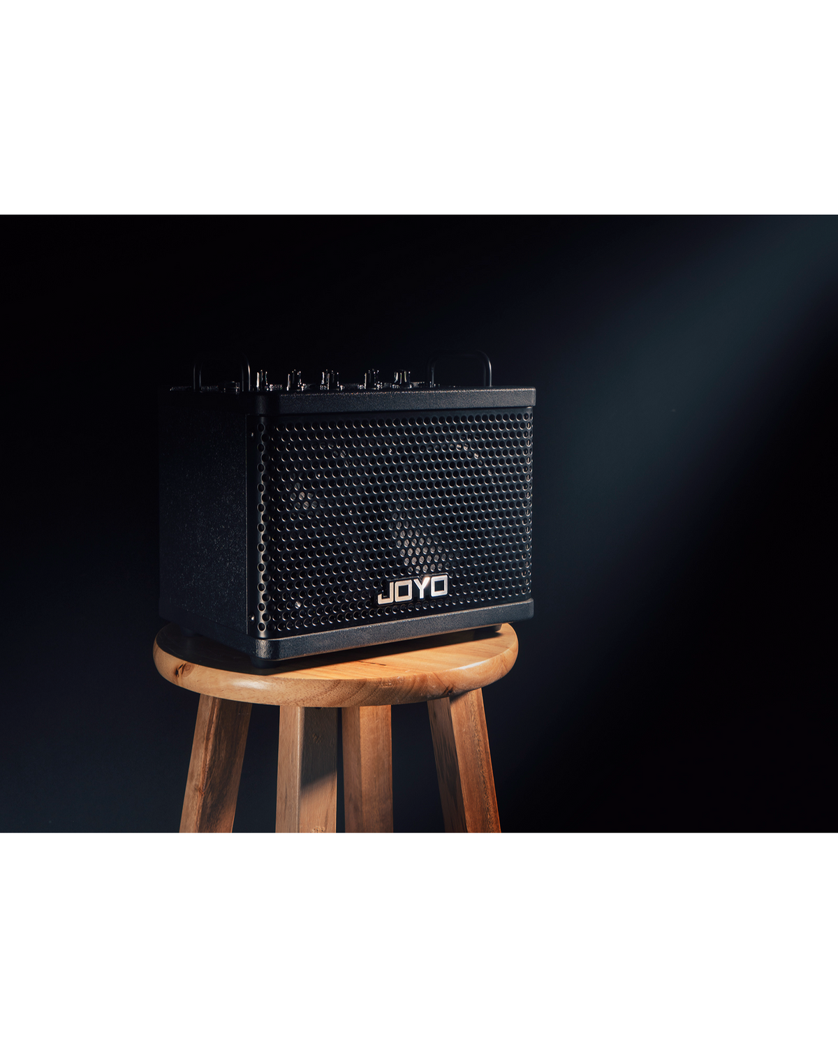 Haze Guitar Australia Joyo DC15S 15W portable digital guitar amplifier on a wooden stool against a dark background
